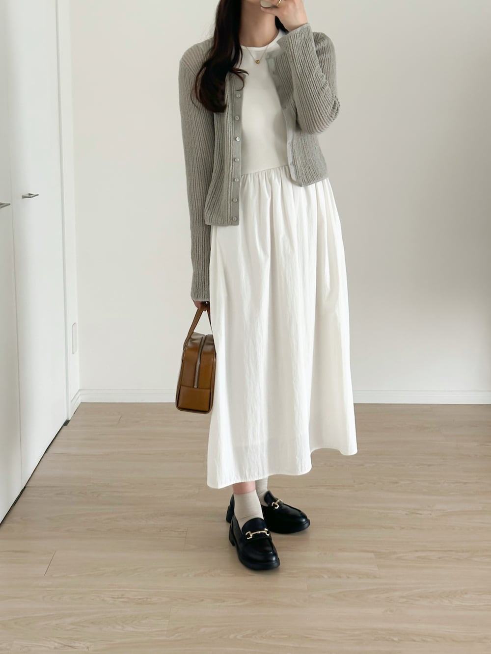 ブラック系のローファー、ブラウン系のバッグ、グレー系のカーディガン/ボレロを着用したレディースの夏コーディネートの3枚目の写真