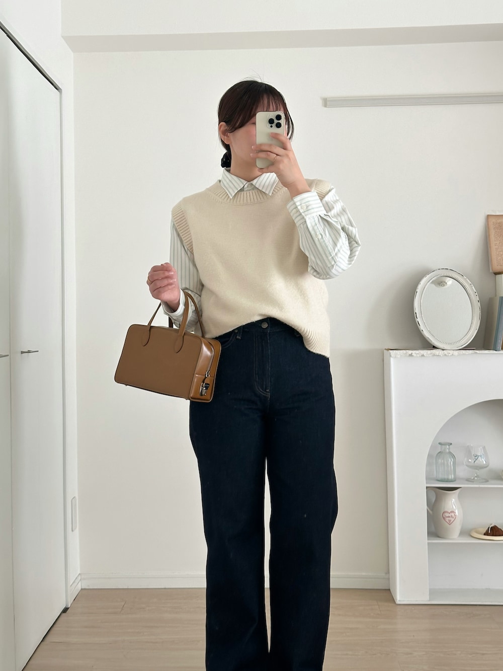 ブルー系のデニムパンツ、ホワイト系のベスト、ホワイト系のシャツ/ブラウスを着用したレディースの冬コーディネートの2枚目の写真