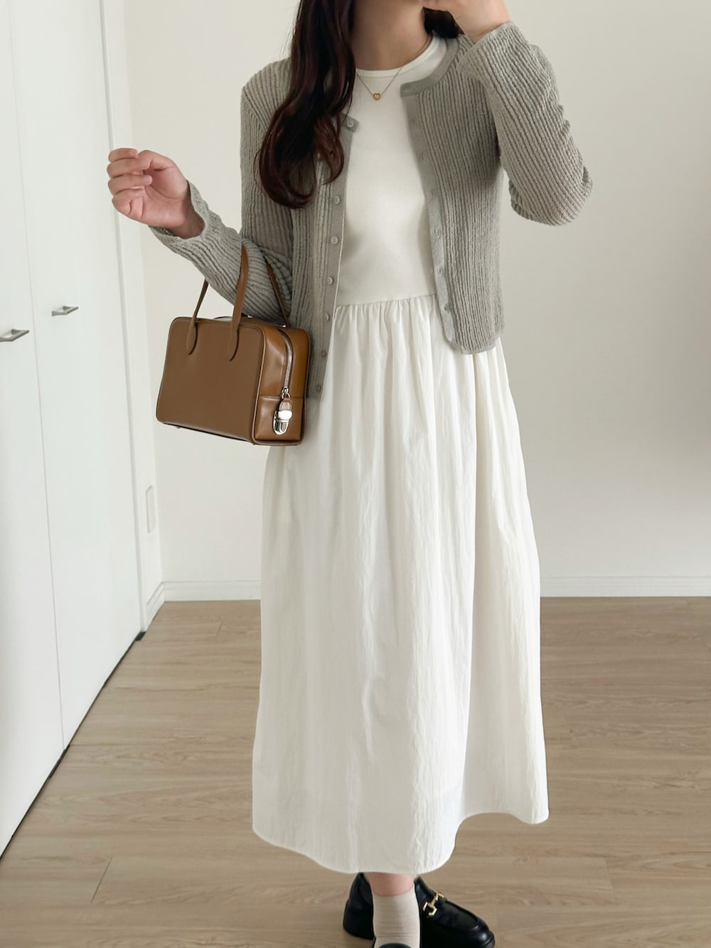 ブラック系のローファー、ブラウン系のバッグ、グレー系のカーディガン/ボレロを着用したレディースの夏コーディネートの4枚目の写真