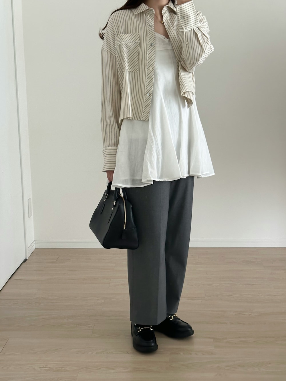 ホワイト系のワンピース/ドレス、グレー系のパンツ、ブラック系のバッグを着用したレディースの春コーディネートの2枚目の写真