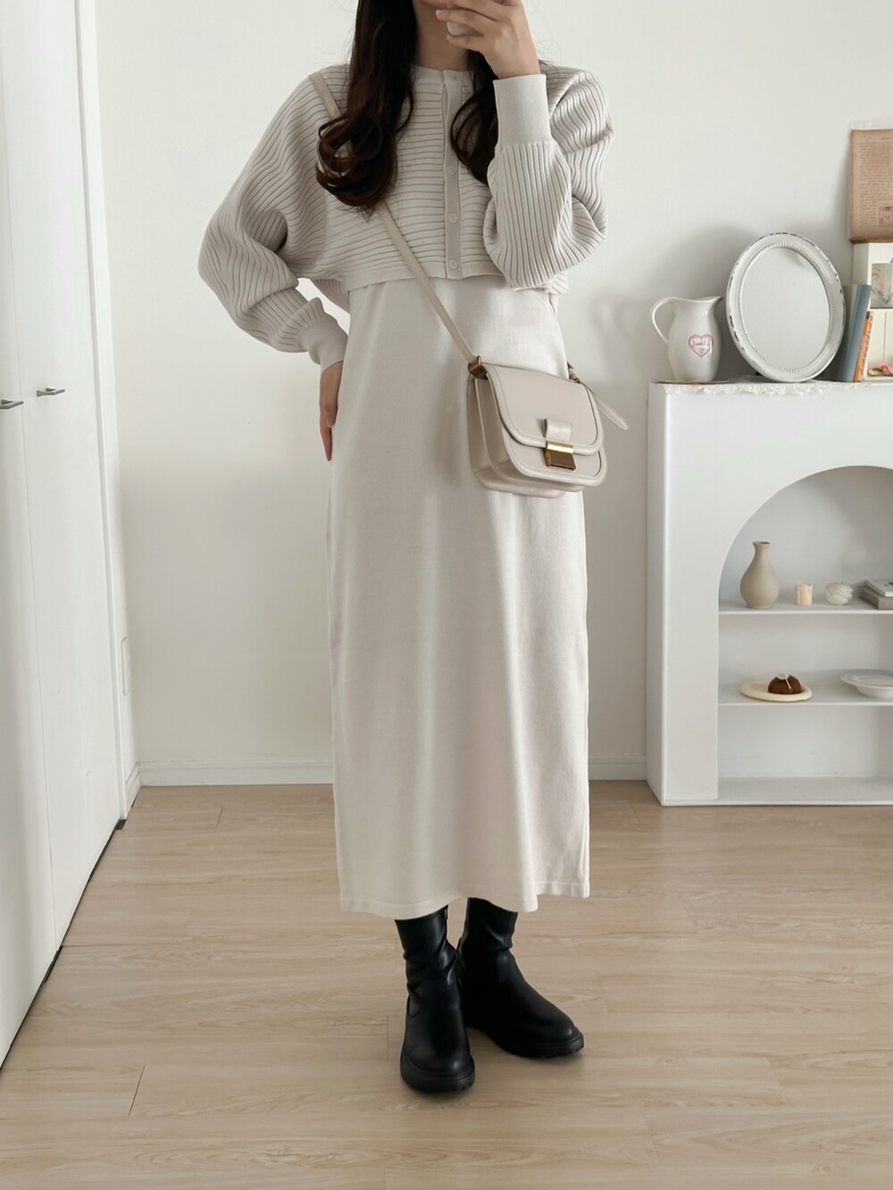 ブラック系のブーツ、ホワイト系のワンピース/ドレスを着用したレディースの冬コーディネートの2枚目の写真