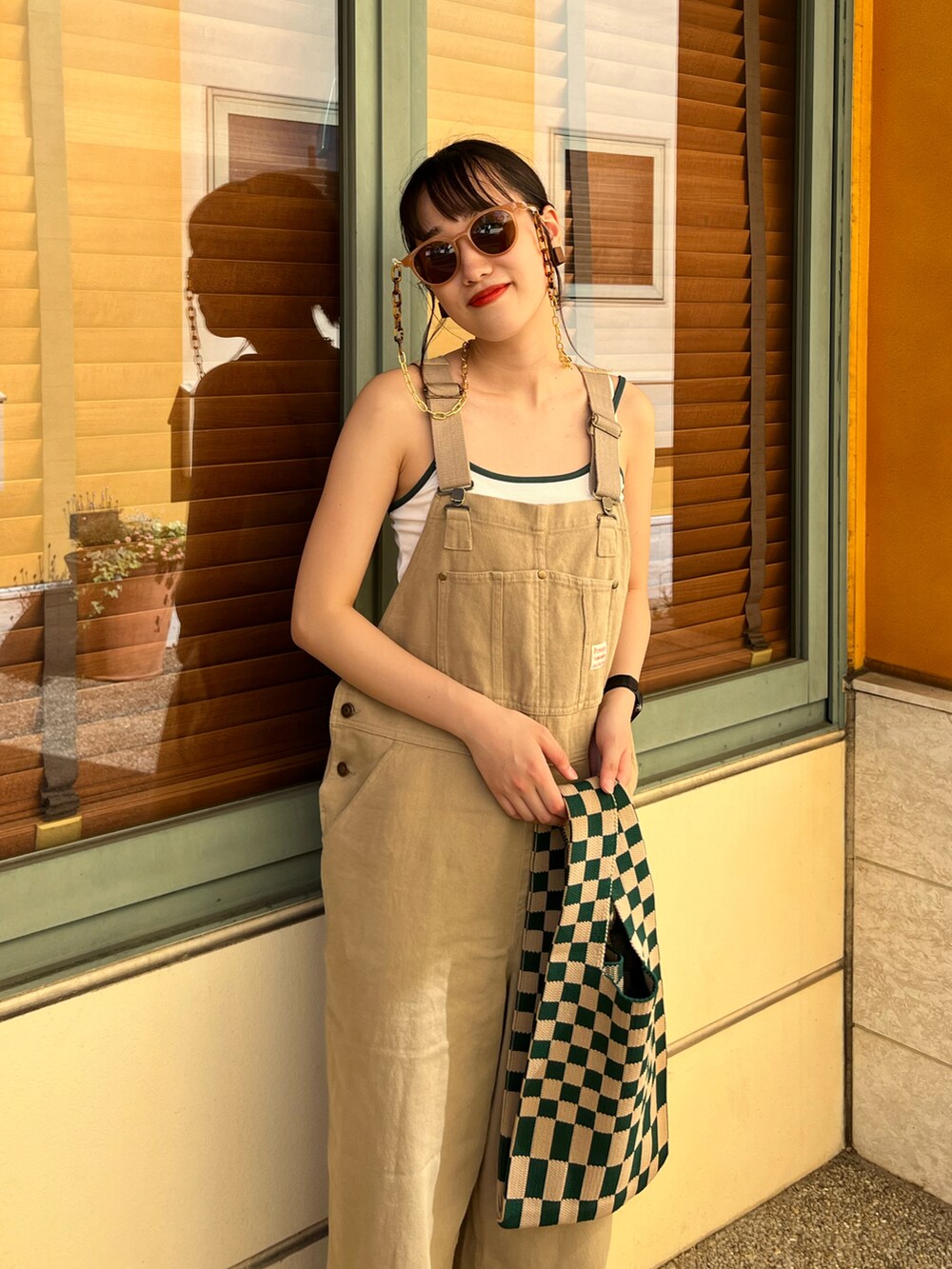 ベージュ系のサロペット/オーバーオール、グリーン系のスウェットパンツ、グリーン系のトートバッグを着用したレディースの夏コーディネートの3枚目の写真