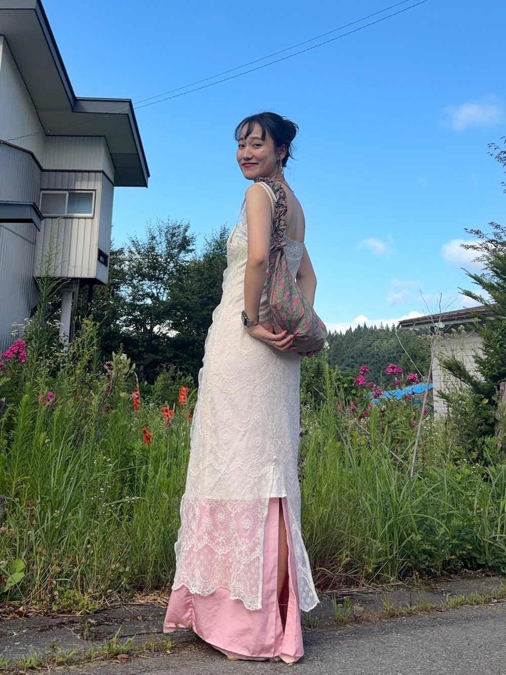 ホワイト系のパンプス、ホワイト系のキャミソール、ピンク系のスカートを着用したレディースの夏コーディネートの2枚目の写真