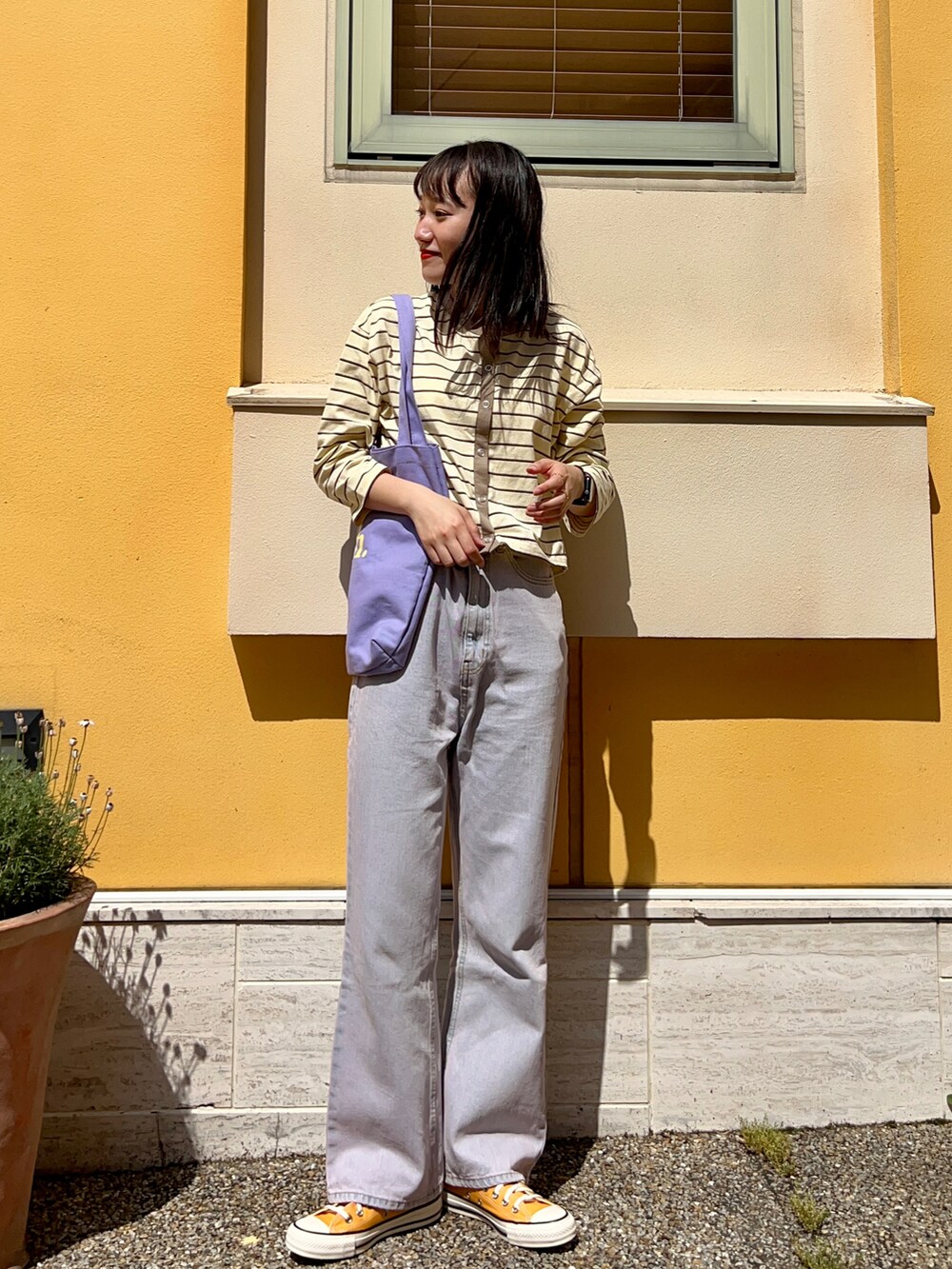 イエロー系のカーディガン/ボレロ、パープル系のトートバッグ、パープル系のデニムパンツを着用したレディースの夏コーディネートの2枚目の写真