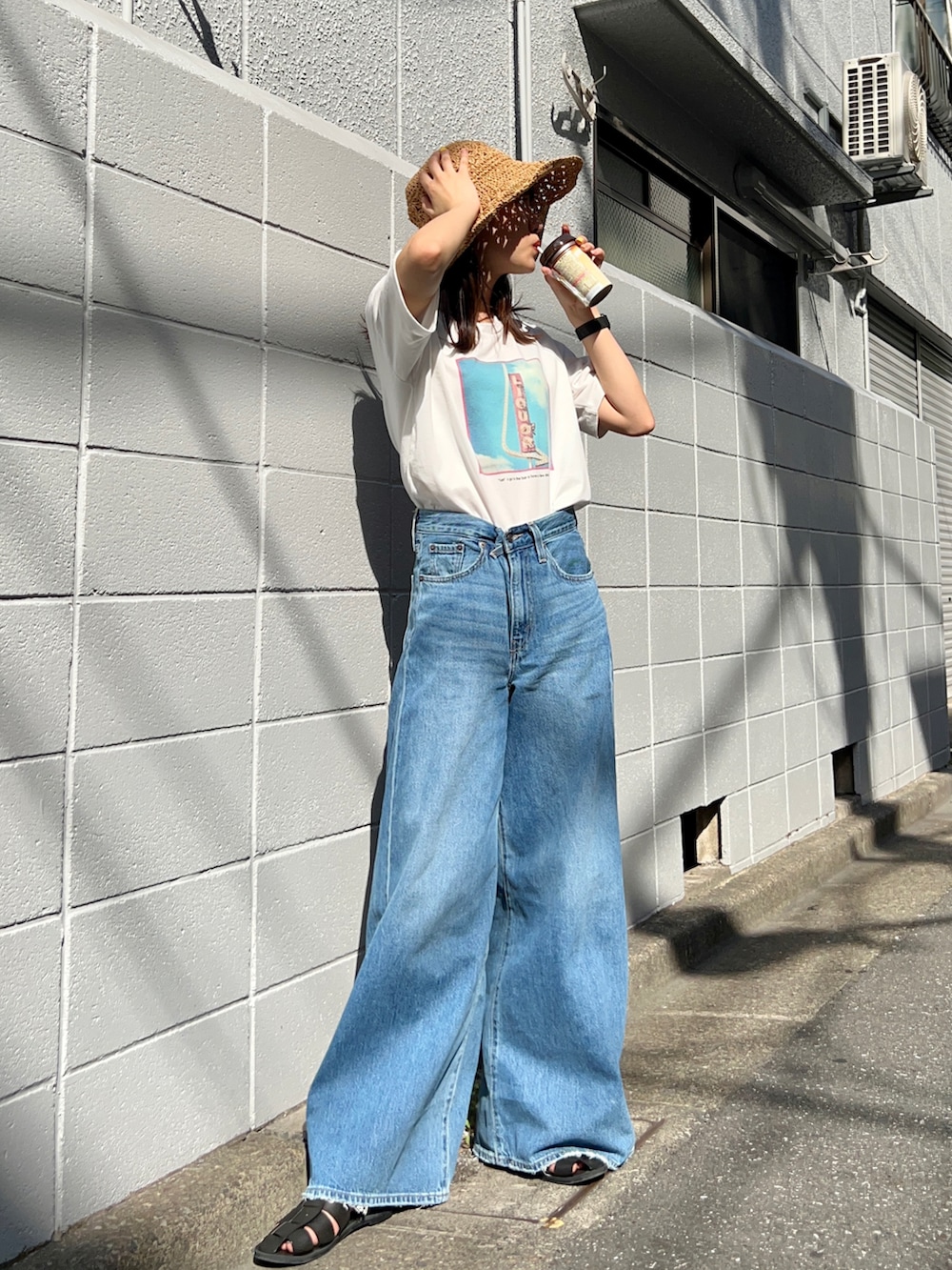 ピンク系のTシャツ/カットソー、ブルー系のデニムパンツ、ブラック系のサンダルを着用したレディースの夏コーディネートの2枚目の写真