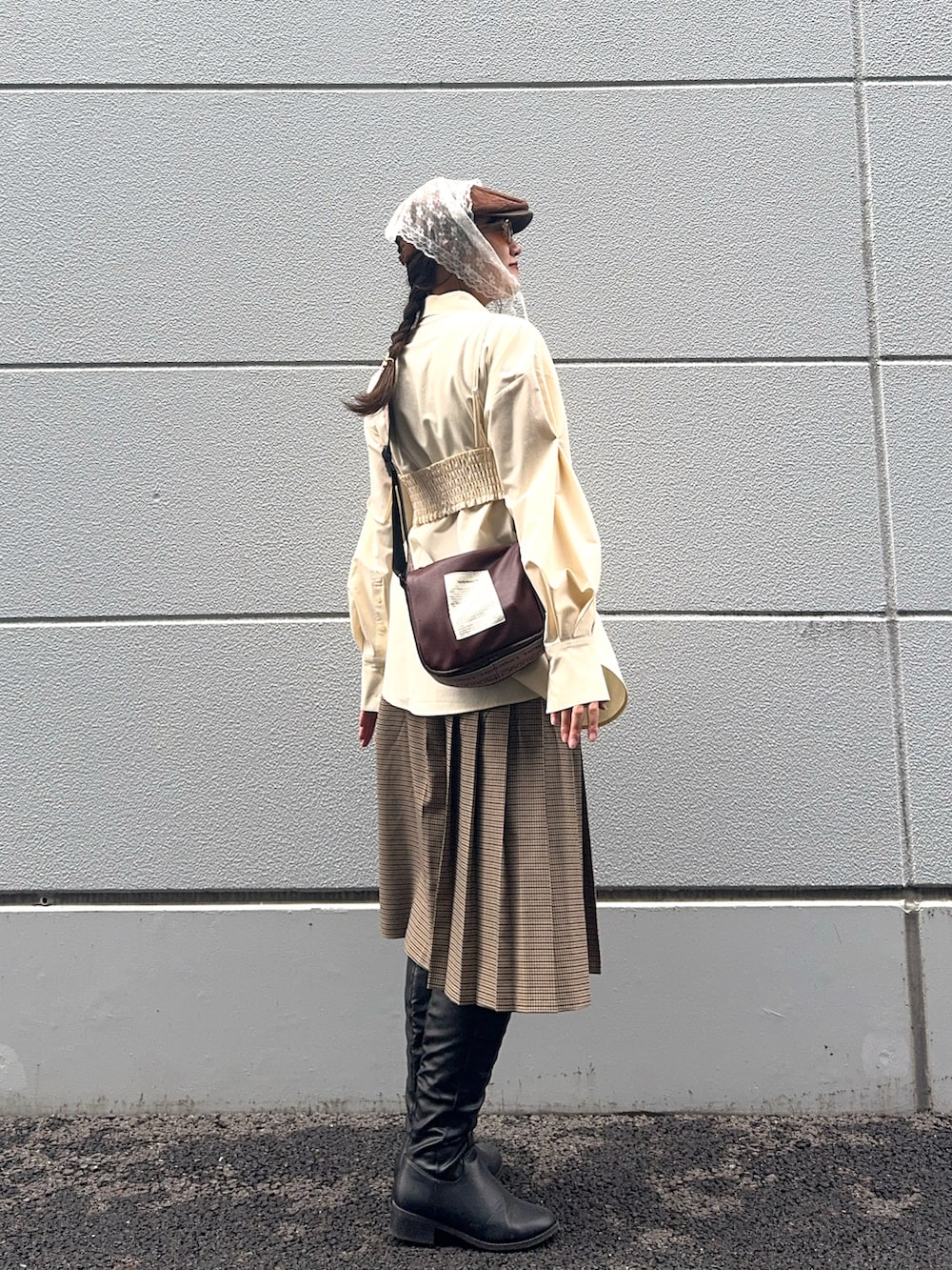 ブラック系のブーツ、ブラウン系のショルダーバッグ、ベージュ系のシャツ/ブラウスを着用したレディースの秋コーディネートの2枚目の写真