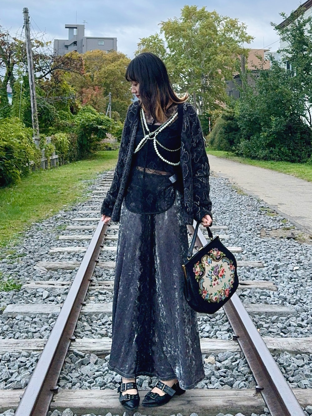 ブラック系のカーディガン/ボレロ、ブラック系のシャツ/ブラウス、グレー系のスカートを着用したレディースの秋コーディネートの2枚目の写真