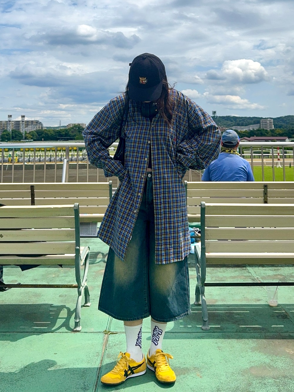 イエロー系のスニーカー、ブラック系のキャップを着用したレディースの夏コーディネートの2枚目の写真