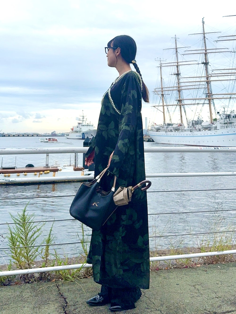 グリーン系のワンピース、ホワイト系のサスペンダーを着用したレディースの秋コーディネートの2枚目の写真