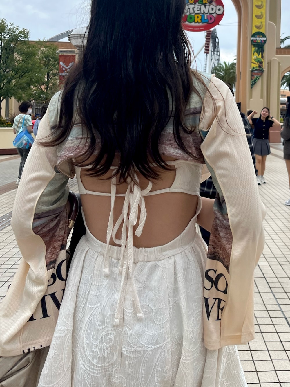 ホワイト系のシャツ/ブラウス、グレー系のスラックス、ブラウン系のショルダーバッグを着用したレディースの秋コーディネートの3枚目の写真