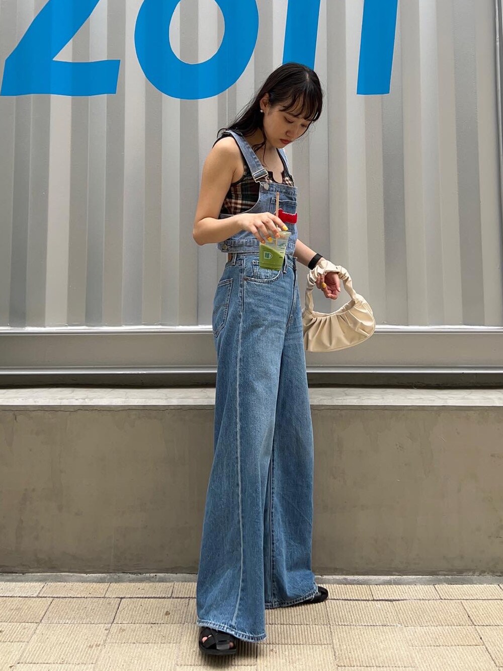 ブルー系のタンクトップ、グリーン系のタンクトップ、ホワイト系のハンドバッグを着用したレディースの夏コーディネートの2枚目の写真