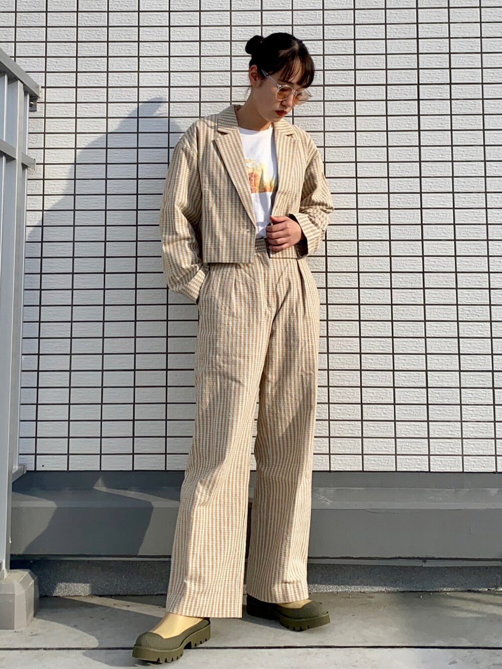 オレンジ系のテーラードジャケット、ホワイト系のTシャツ/カットソー、オレンジ系のその他パンツを着用したレディースの春コーディネートの2枚目の写真