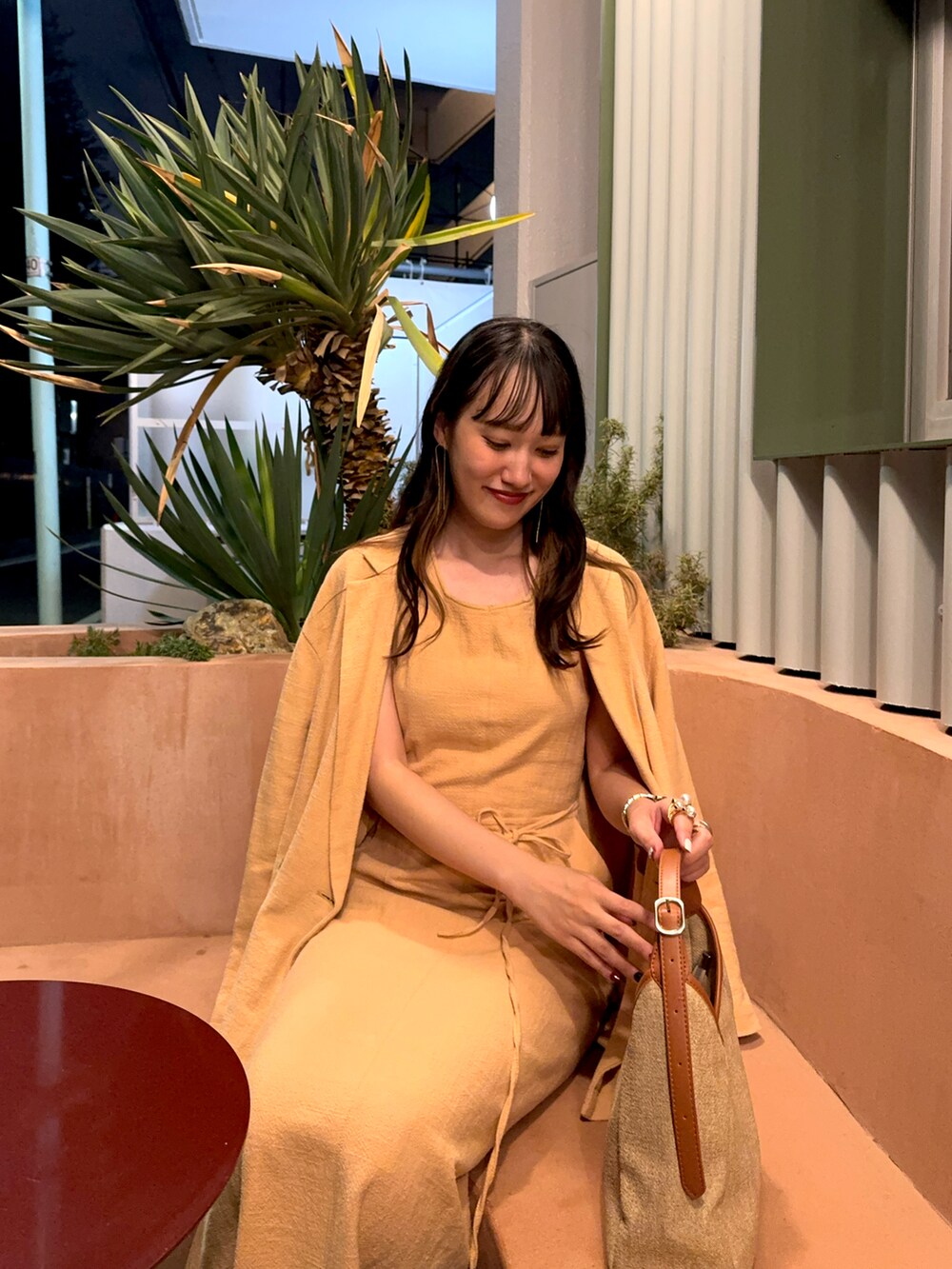 オレンジ系のワンピース、オレンジ系のテーラードジャケット、ベージュ系のハンドバッグを着用したレディースの秋コーディネートの2枚目の写真