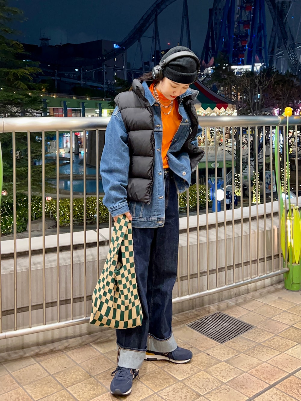 ブルー系のデニムジャケット、オレンジ系のTシャツ/カットソー、ブルー系のデニムパンツを着用したレディースの冬コーディネートの2枚目の写真