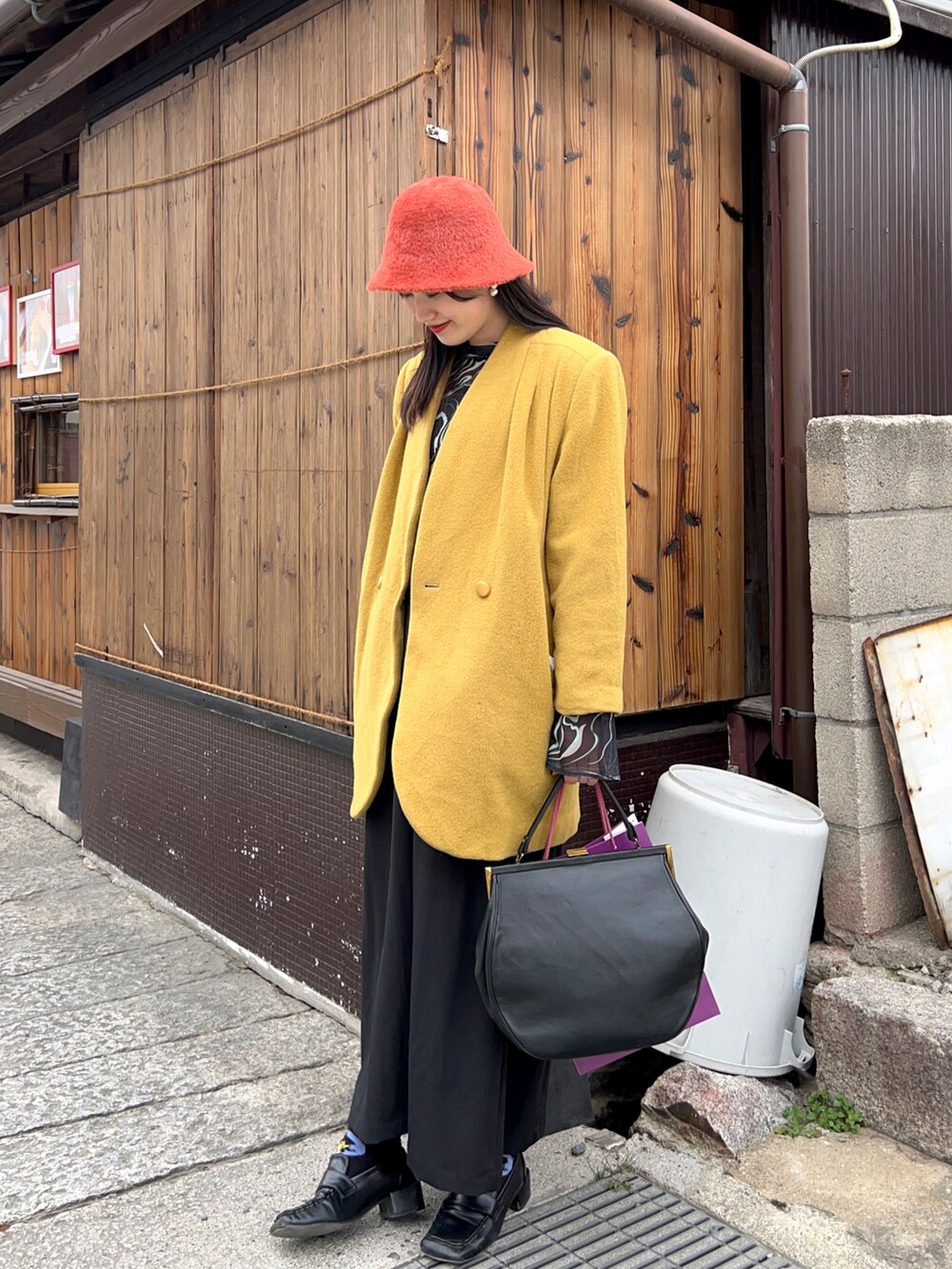 ブラック系のジャンパースカート、ブラック系のローファー、その他のTシャツ/カットソーを着用したレディースの冬コーディネートの2枚目の写真