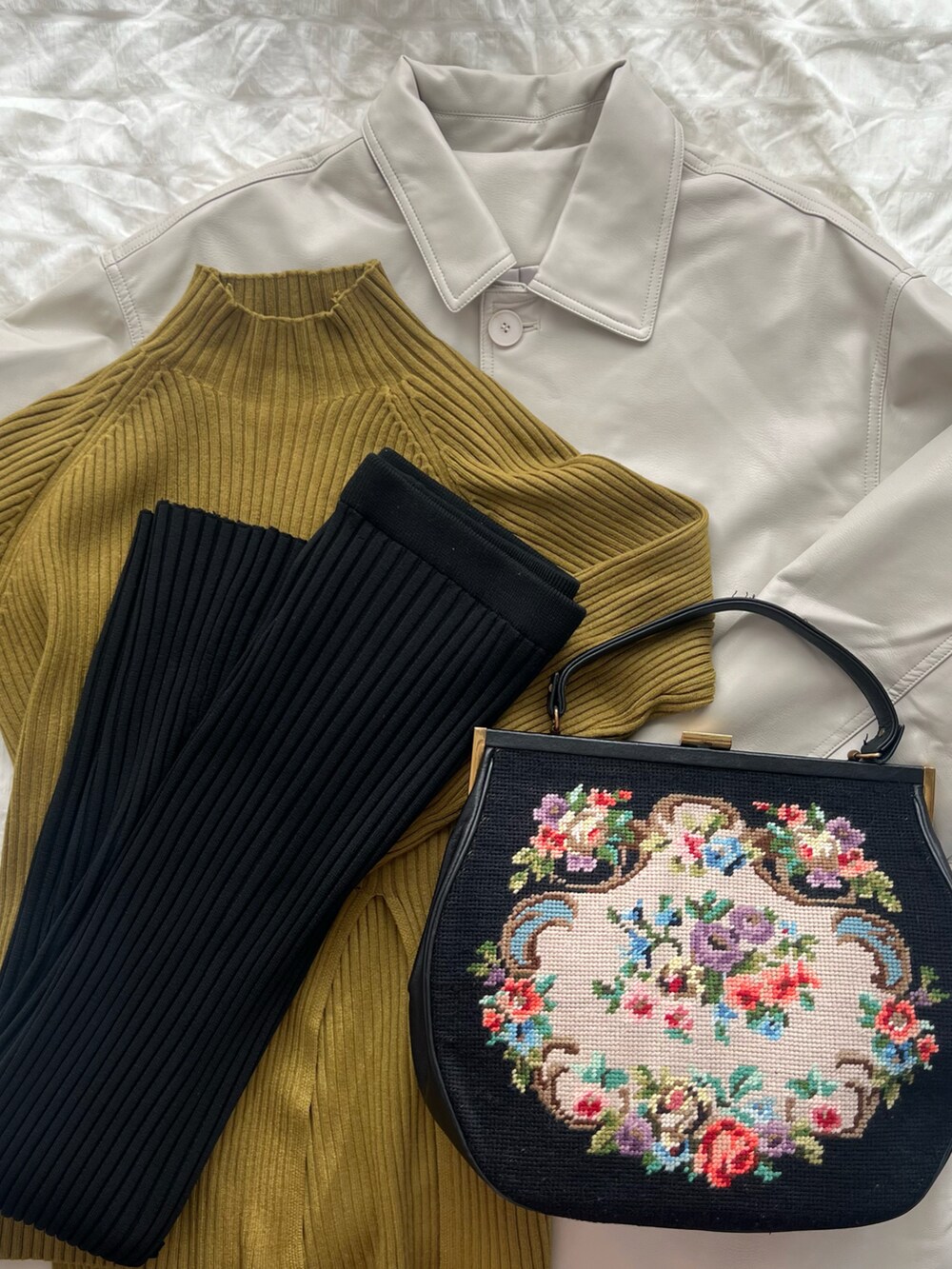 ホワイト系のその他アウター、グリーン系のニット/セーター、ブラック系のハンドバッグを着用したレディースの春コーディネートの3枚目の写真