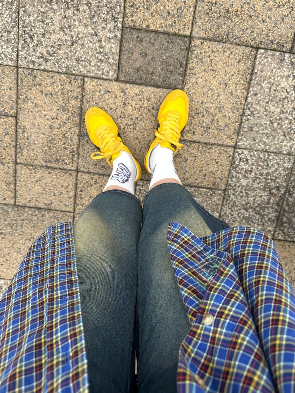 イエロー系のスニーカー、ブラック系のキャップを着用したレディースの夏コーディネートの3枚目の写真