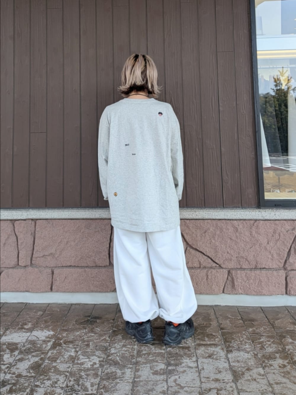 ベージュ系のTシャツ/カットソー、ブラック系のモッズコート、ホワイト系のその他パンツを着用したレディースの冬コーディネートの7枚目の写真