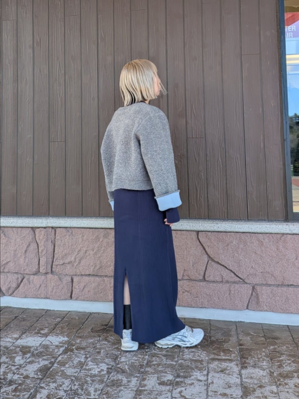 グレー系のカーディガン/ボレロ、ブルー系のワンピース、ホワイト系のスニーカーを着用したレディースの冬コーディネートの3枚目の写真