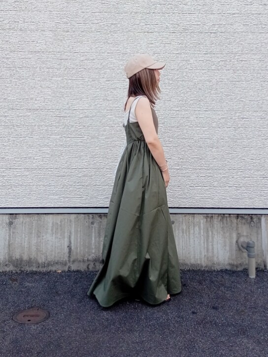 ホワイト系のバッグ、グリーン系のワンピース、ベージュ系のキャップを着用したレディースの夏コーディネートの2枚目の写真