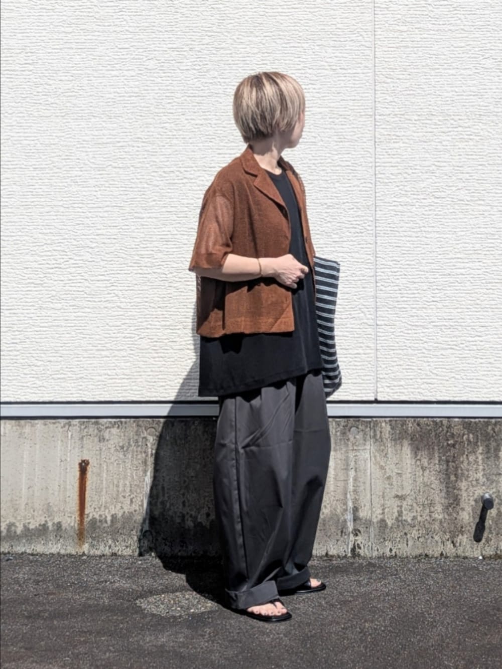 ブラック系のTシャツ/カットソー、グレー系のその他パンツ、ブラック系のサンダルを着用したレディースの夏コーディネートの2枚目の写真