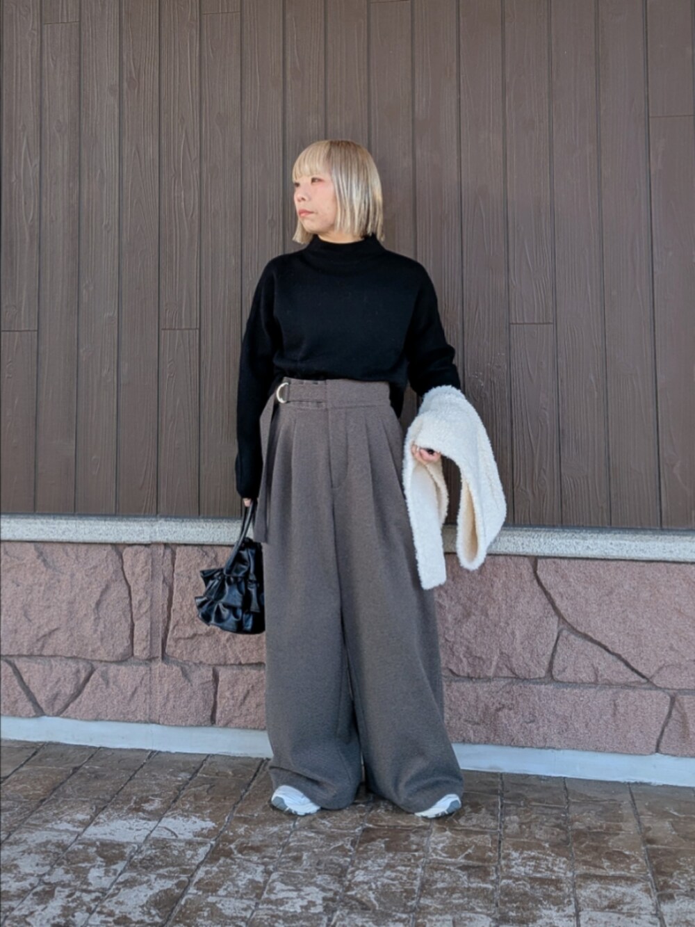 ブラック系のニット/セーター、ブラック系のその他パンツ、ブラック系のハンドバッグを着用したレディースの冬コーディネートの4枚目の写真
