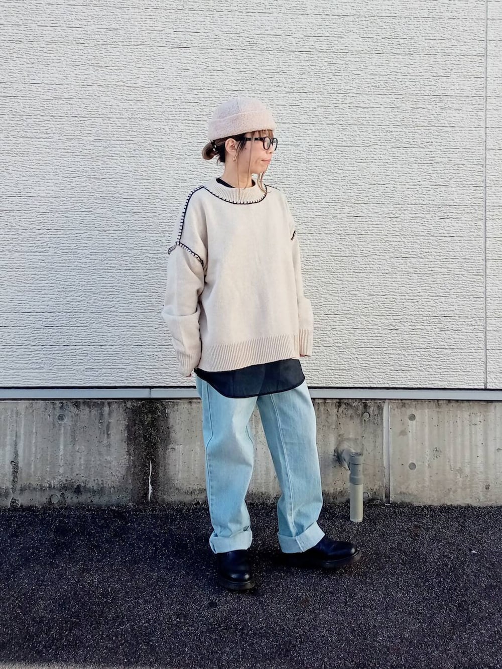 ブルー系のデニムパンツ、ホワイト系のニット/セーター、ブラック系のシャツ/ブラウスを着用したレディースの秋コーディネートの3枚目の写真