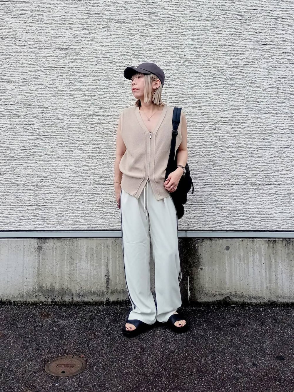 ブラック系のバックパック/リュック、ホワイト系のその他パンツ、ベージュ系のベストを着用したレディースの夏コーディネートの2枚目の写真