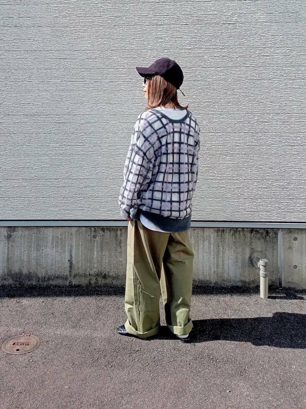 グレー系のニット/セーター、グリーン系のチノパンツ、ブラック系のメガネを着用したレディースの秋コーディネートの5枚目の写真