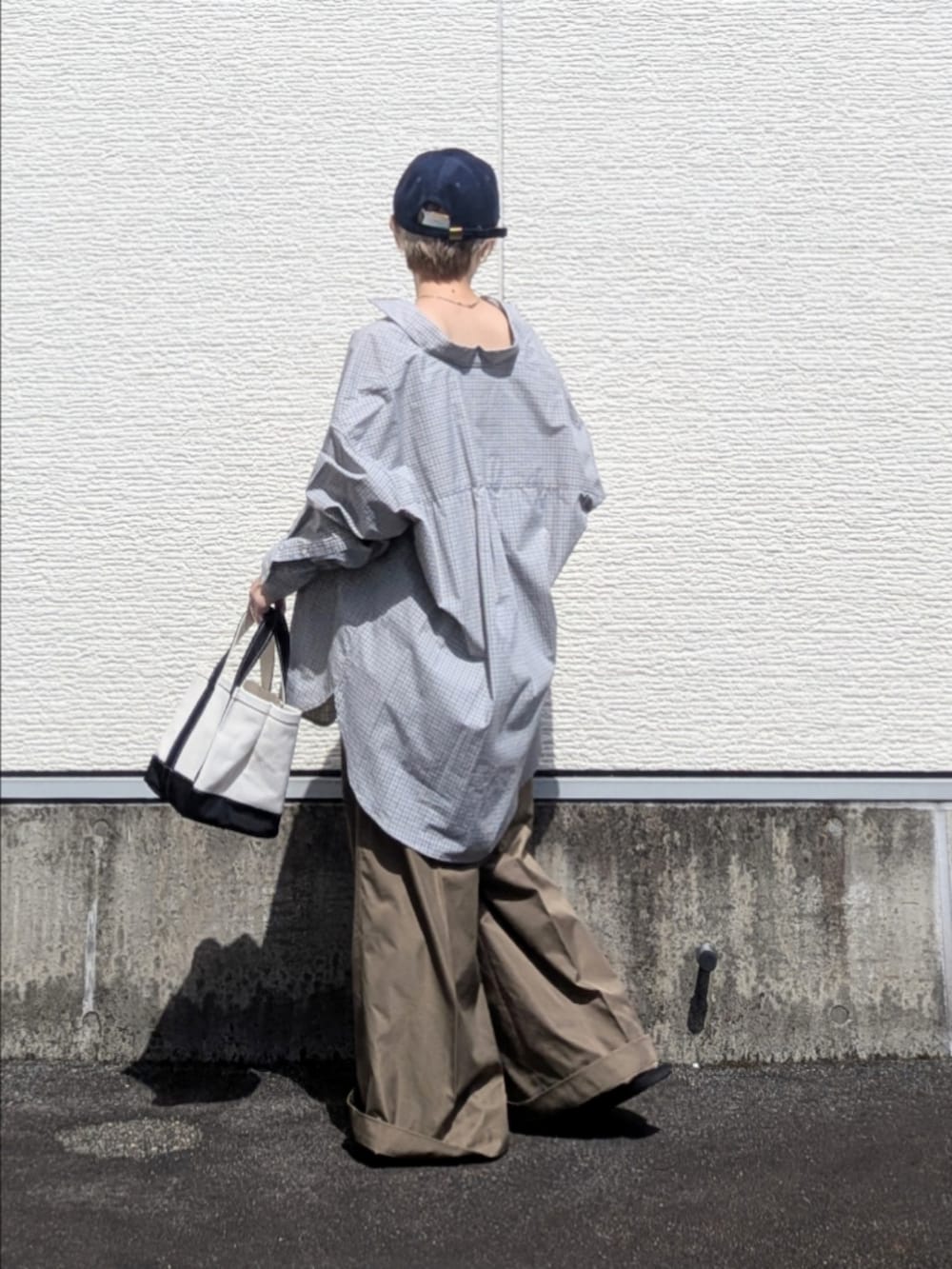 ブルー系のシャツ/ブラウス、ベージュ系のチノパンツ、ブラック系のトートバッグを着用したレディースの秋コーディネートの3枚目の写真