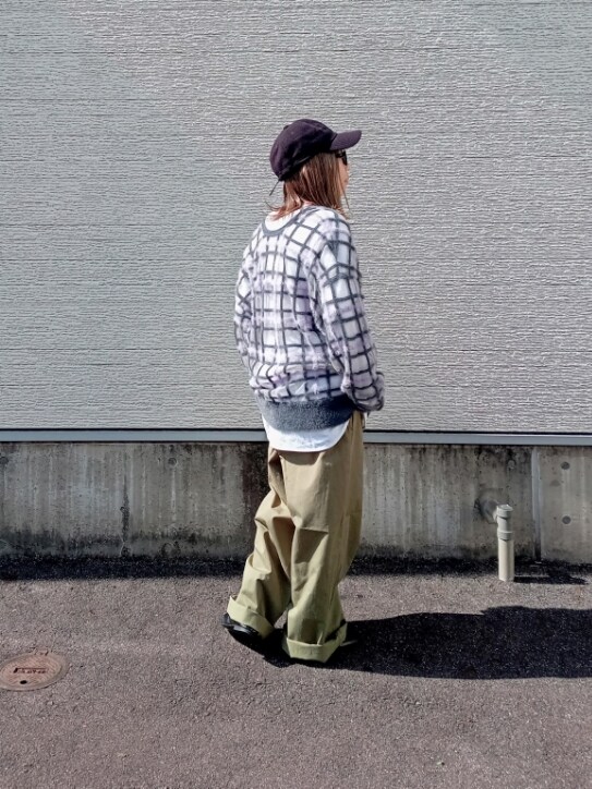 グレー系のニット/セーター、グリーン系のチノパンツ、ブラック系のキャップを着用したレディースの秋コーディネートの3枚目の写真