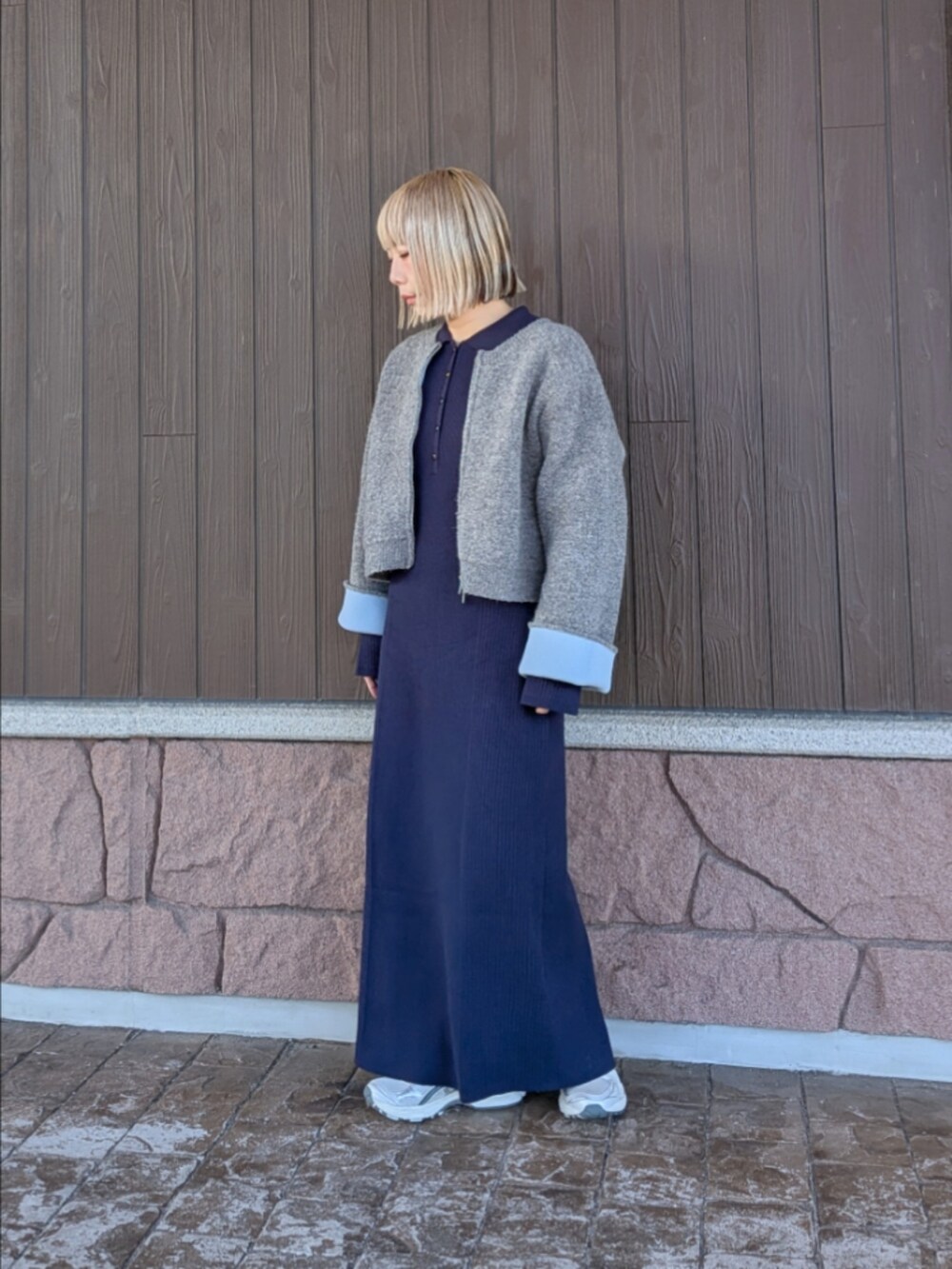 グレー系のカーディガン/ボレロ、ブルー系のワンピース、ホワイト系のスニーカーを着用したレディースの冬コーディネートの2枚目の写真