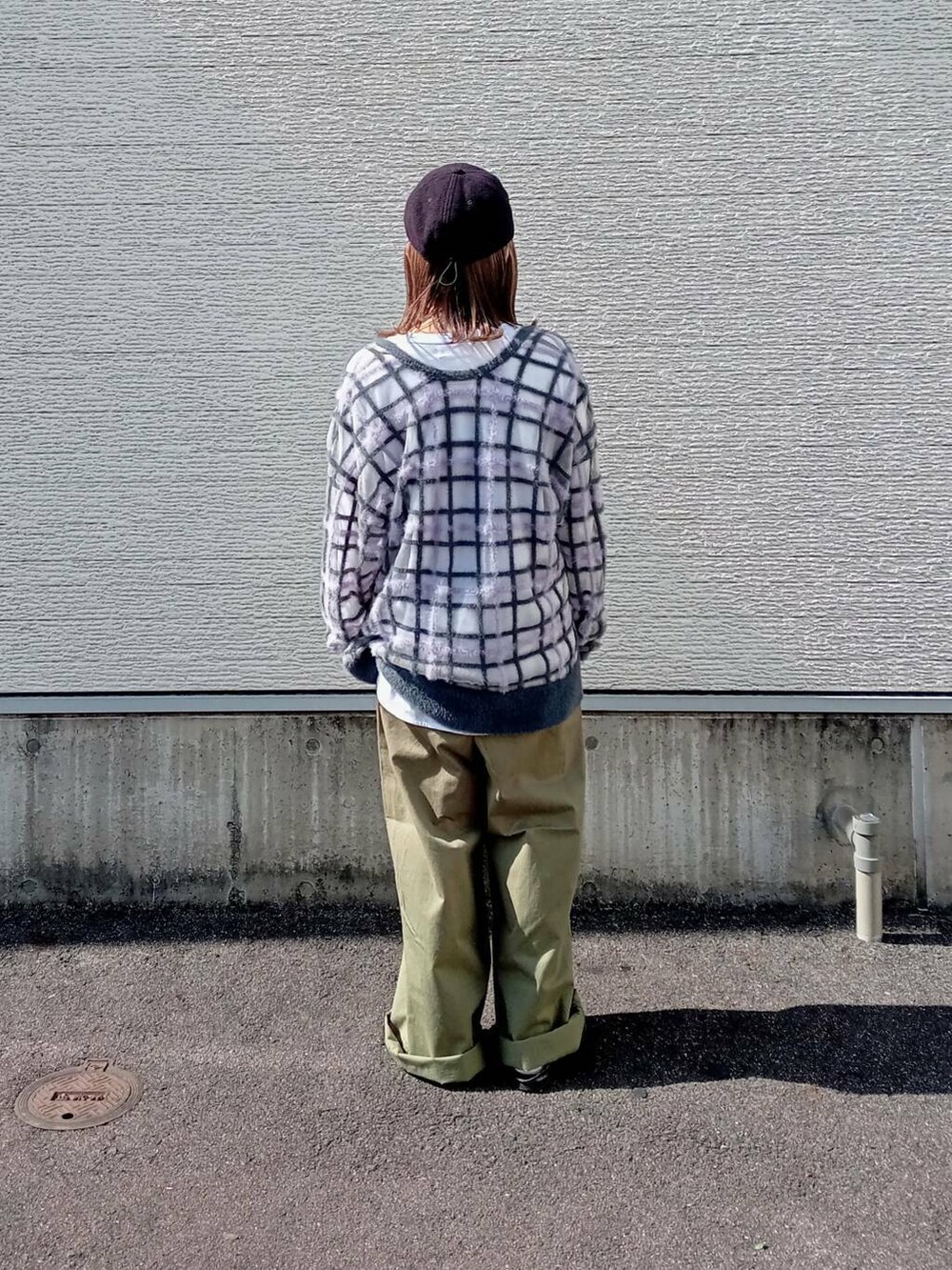 グレー系のニット/セーター、グリーン系のチノパンツ、ブラック系のメガネを着用したレディースの秋コーディネートの4枚目の写真