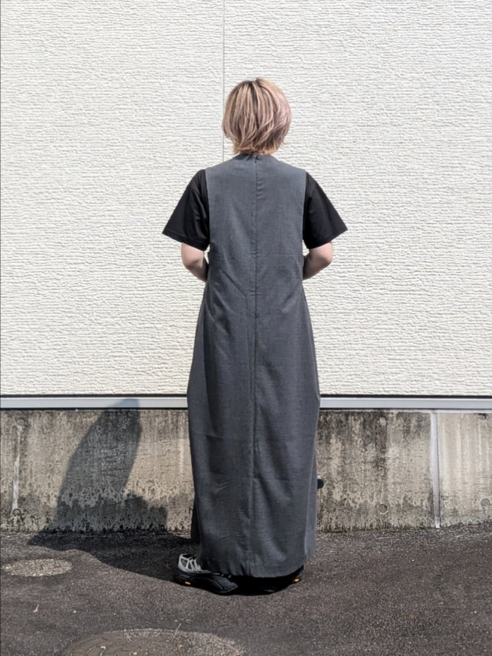 グレー系のワンピース、ブラック系のTシャツ/カットソー、ブラック系のスニーカーを着用したレディースの夏コーディネートの4枚目の写真