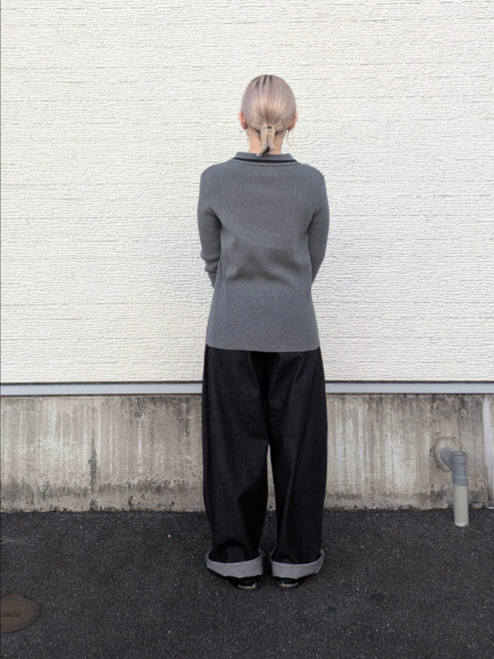 グレー系のニット/セーター、ブラック系のデニムパンツ、グレー系のハンドバッグを着用したレディースの冬コーディネートの2枚目の写真