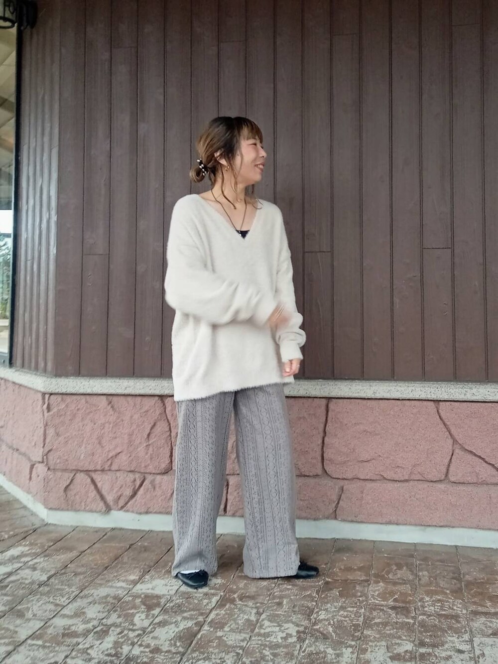 グレー系のその他パンツ、ホワイト系のニット/セーターを着用したレディースの秋コーディネートの2枚目の写真