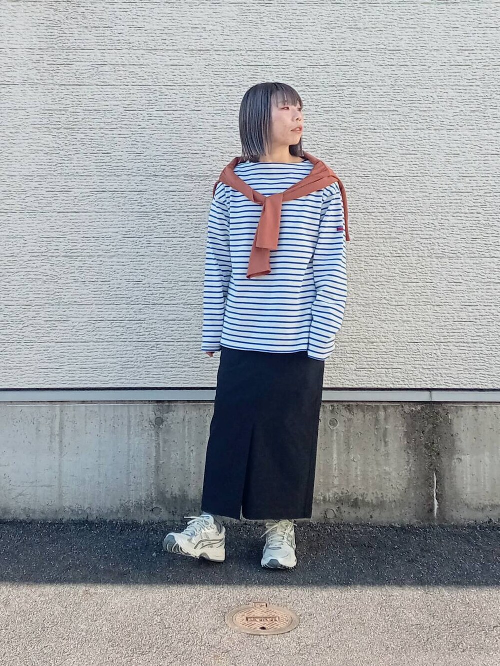 ブラック系のスカート、ブルー系のTシャツ/カットソー、オレンジ系のカーディガン/ボレロを着用したレディースの春コーディネートの4枚目の写真