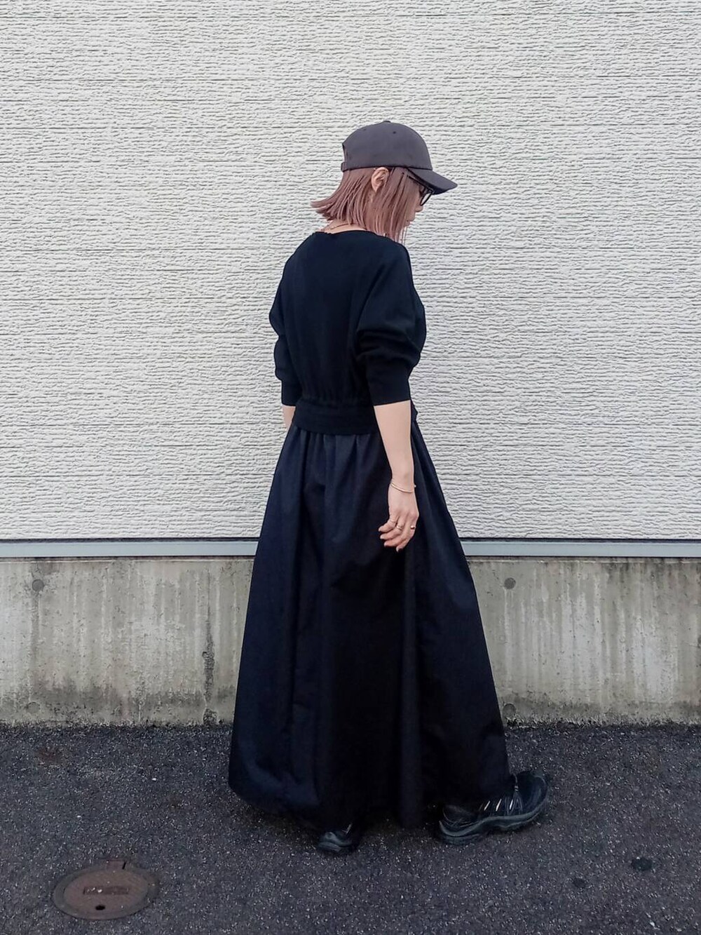 ブラック系のワンピース、グレー系のキャップを着用したレディースの春コーディネートの3枚目の写真