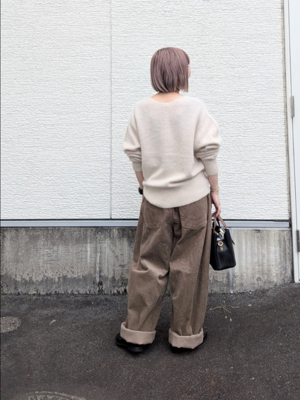 ベージュ系のその他パンツ、ブラック系のローファー、ブラック系のハンドバッグを着用したレディースの秋コーディネートの4枚目の写真