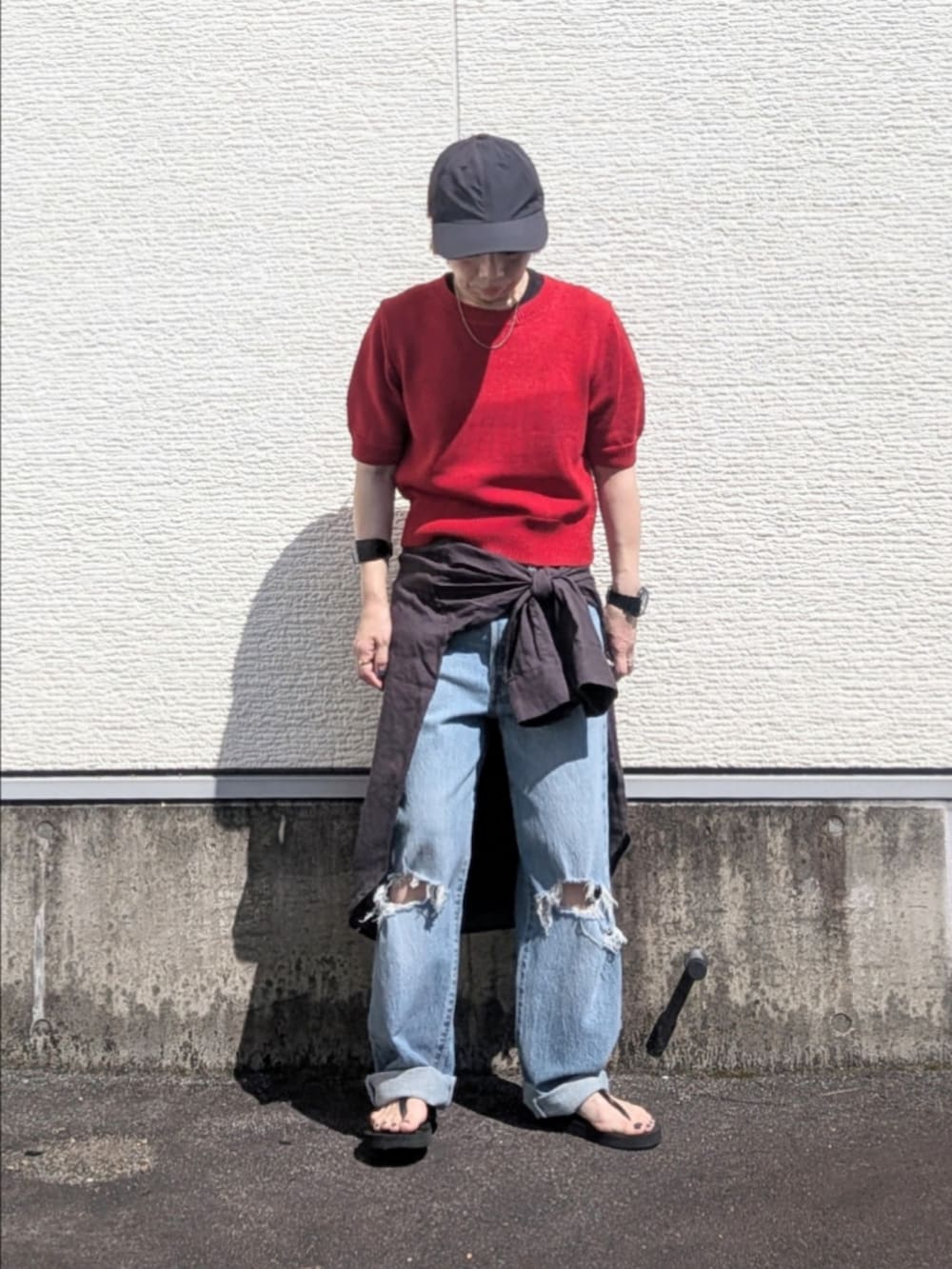 レッド系のニット/セーター、ブルー系のデニムパンツ、グレー系のシャツ/ブラウスを着用したレディースの夏コーディネートの4枚目の写真