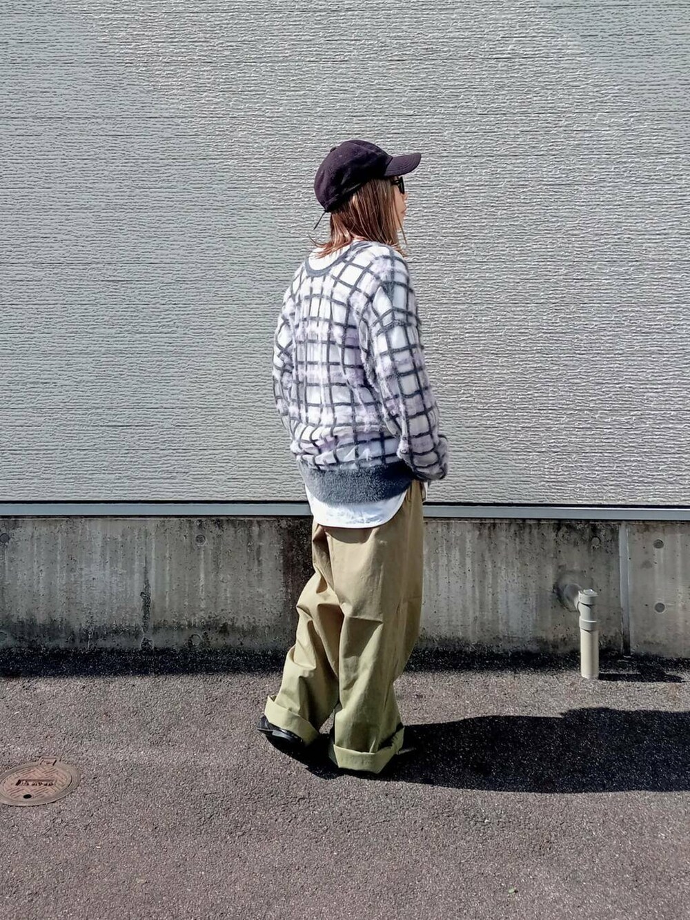 グレー系のニット/セーター、グリーン系のチノパンツ、ブラック系のメガネを着用したレディースの秋コーディネートの3枚目の写真