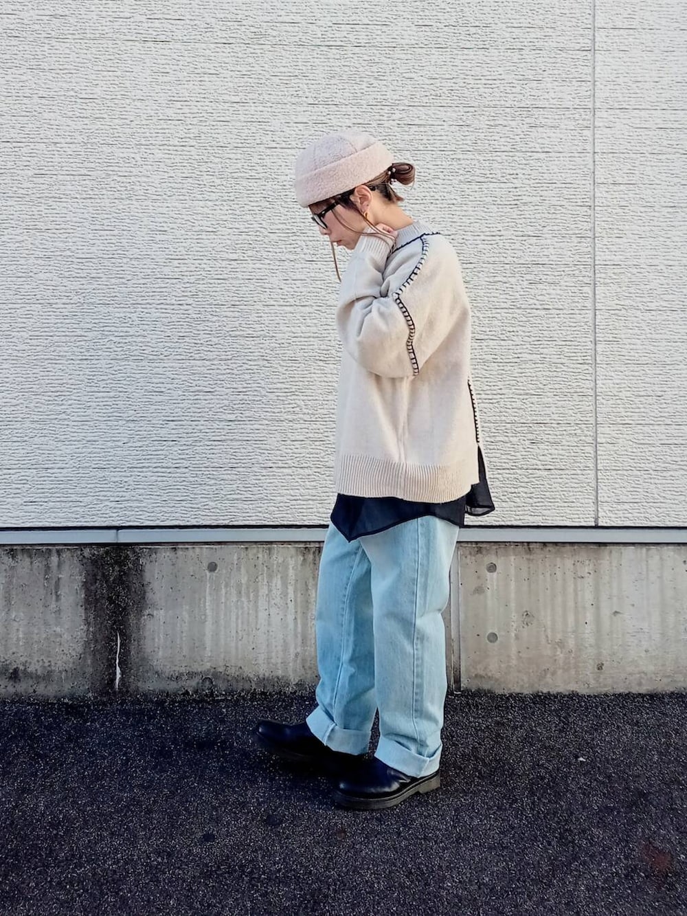 ブルー系のデニムパンツ、ホワイト系のニット/セーター、ブラック系のシャツ/ブラウスを着用したレディースの秋コーディネートの4枚目の写真