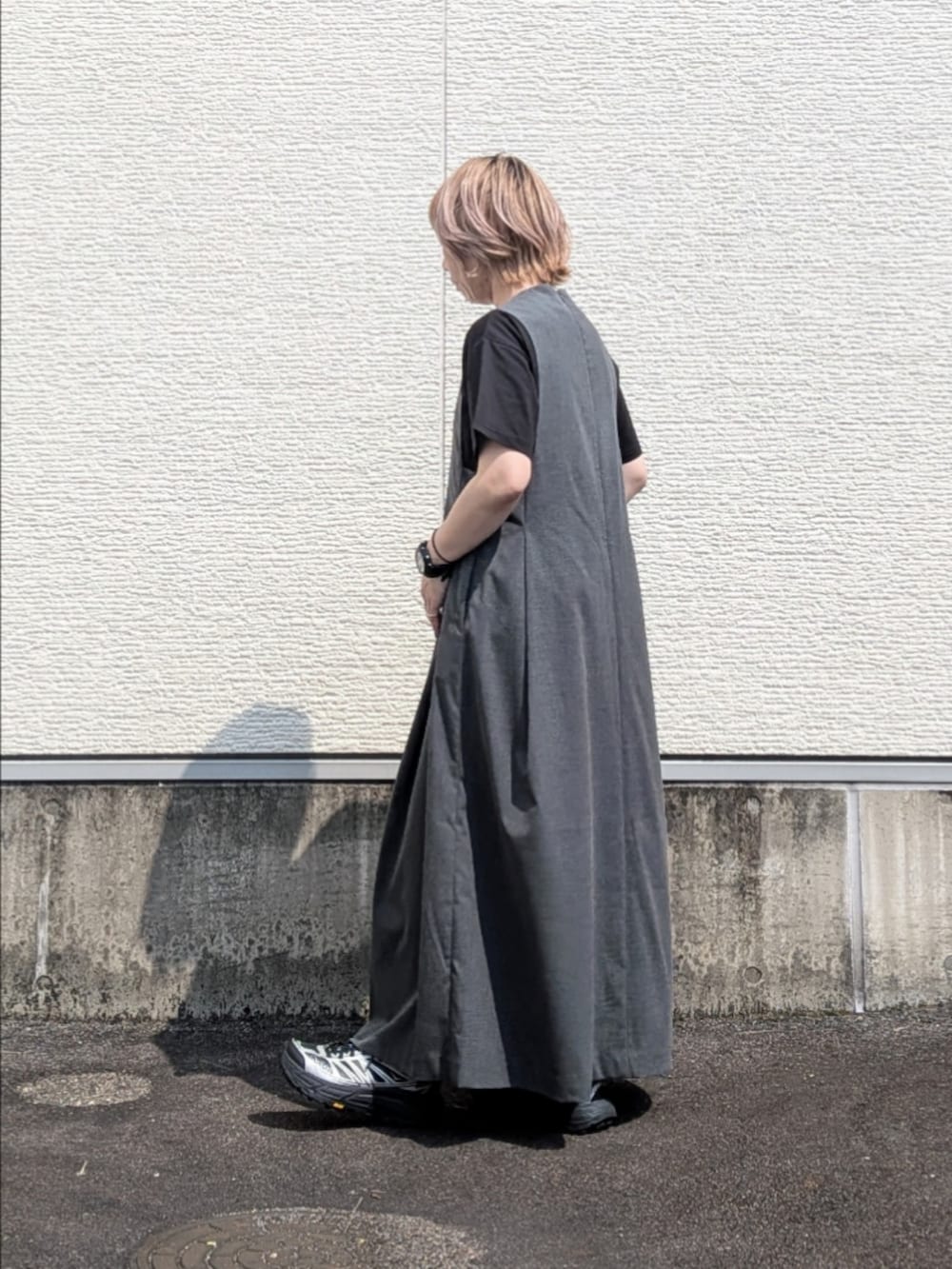 グレー系のワンピース、ブラック系のTシャツ/カットソー、ブラック系のスニーカーを着用したレディースの夏コーディネートの3枚目の写真