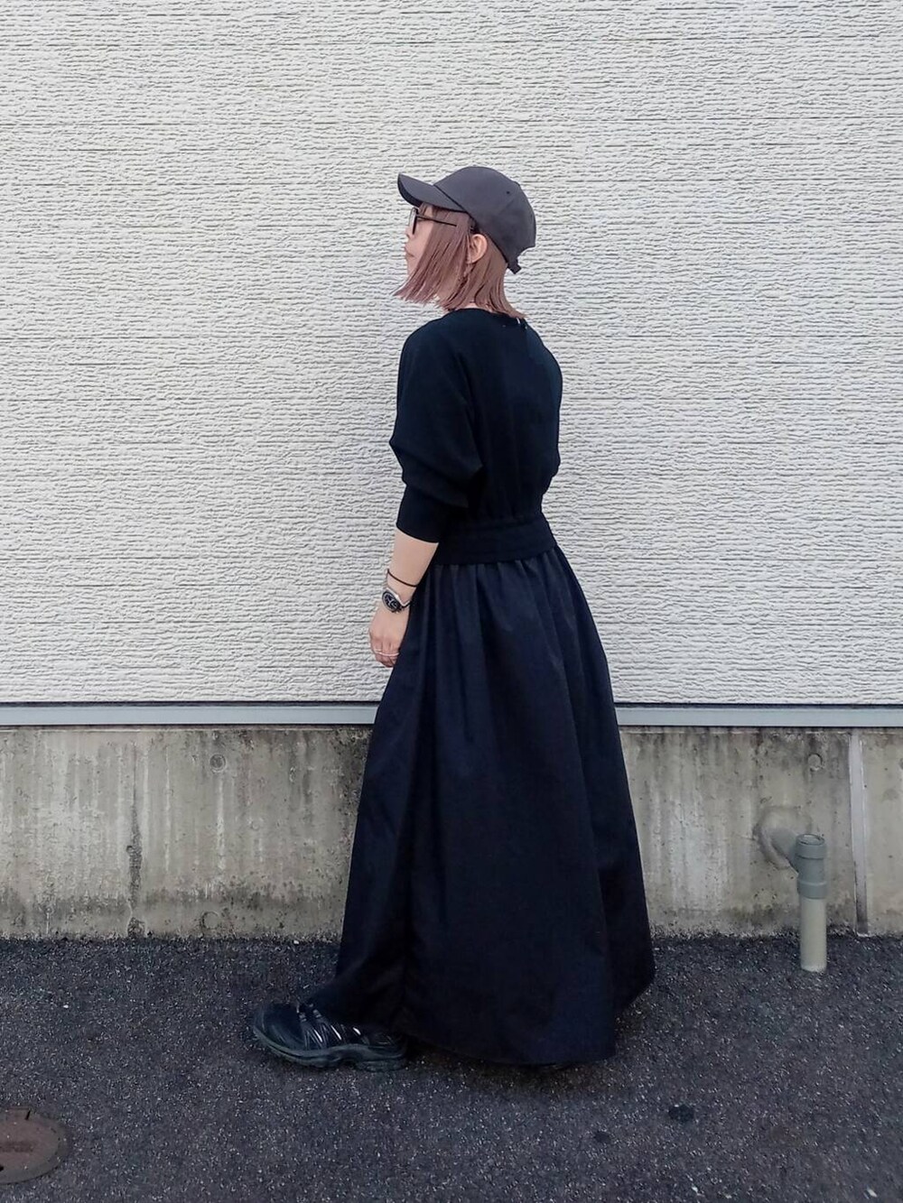 ブラック系のワンピース、グレー系のキャップを着用したレディースの春コーディネートの2枚目の写真