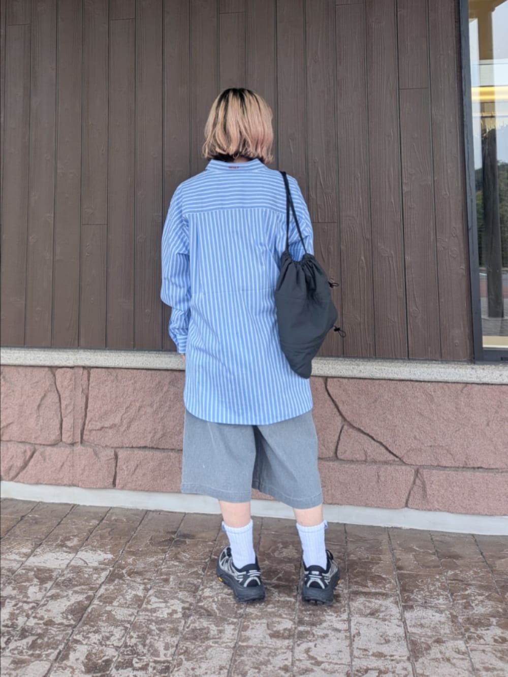 ブルー系のシャツ/ブラウス、グレー系のその他パンツ、ブラック系のスニーカーを着用したレディースの春コーディネートの3枚目の写真