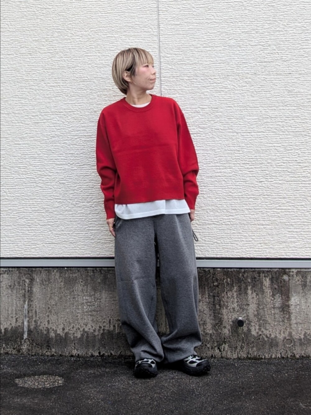 レッド系のニット/セーター、ホワイト系のシャツ/ブラウス、グレー系のその他パンツを着用したレディースの秋コーディネートの3枚目の写真