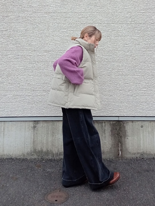 パープル系のニット/セーター、ベージュ系のダウンベスト、ブラック系のデニムパンツを着用したレディースの冬コーディネートの4枚目の写真