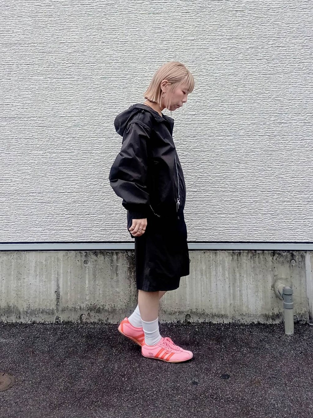 ブラック系のショルダーバッグ、グレー系のマウンテンパーカーを着用したレディースの春コーディネートの2枚目の写真