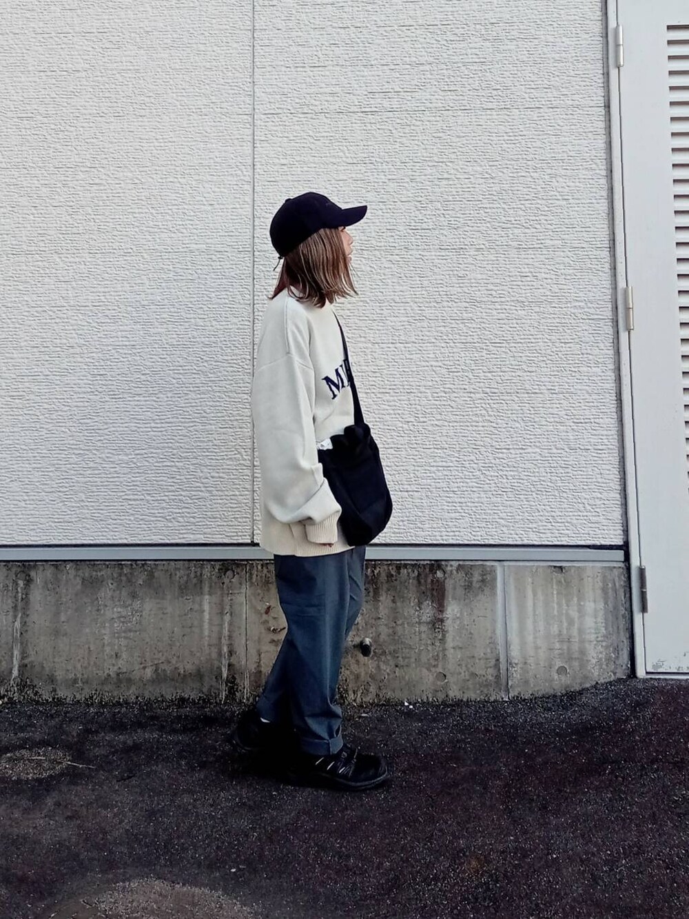 ブラック系のショルダーバッグ、ホワイト系のニット/セーター、グレー系のその他パンツを着用したレディースの秋コーディネートの4枚目の写真