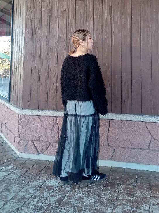 ブラック系のニット/セーター、シルバー系のスカート、ブラック系のスニーカーを着用したレディースの冬コーディネートの4枚目の写真